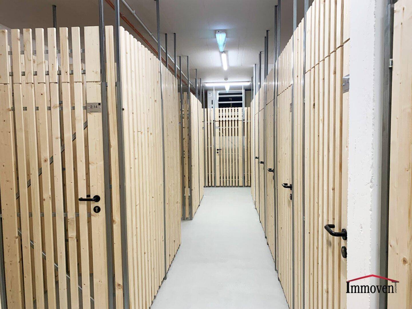 Kellerabteile mit Holzlattenwänden, die zusätzlichen Stauraum bieten.
