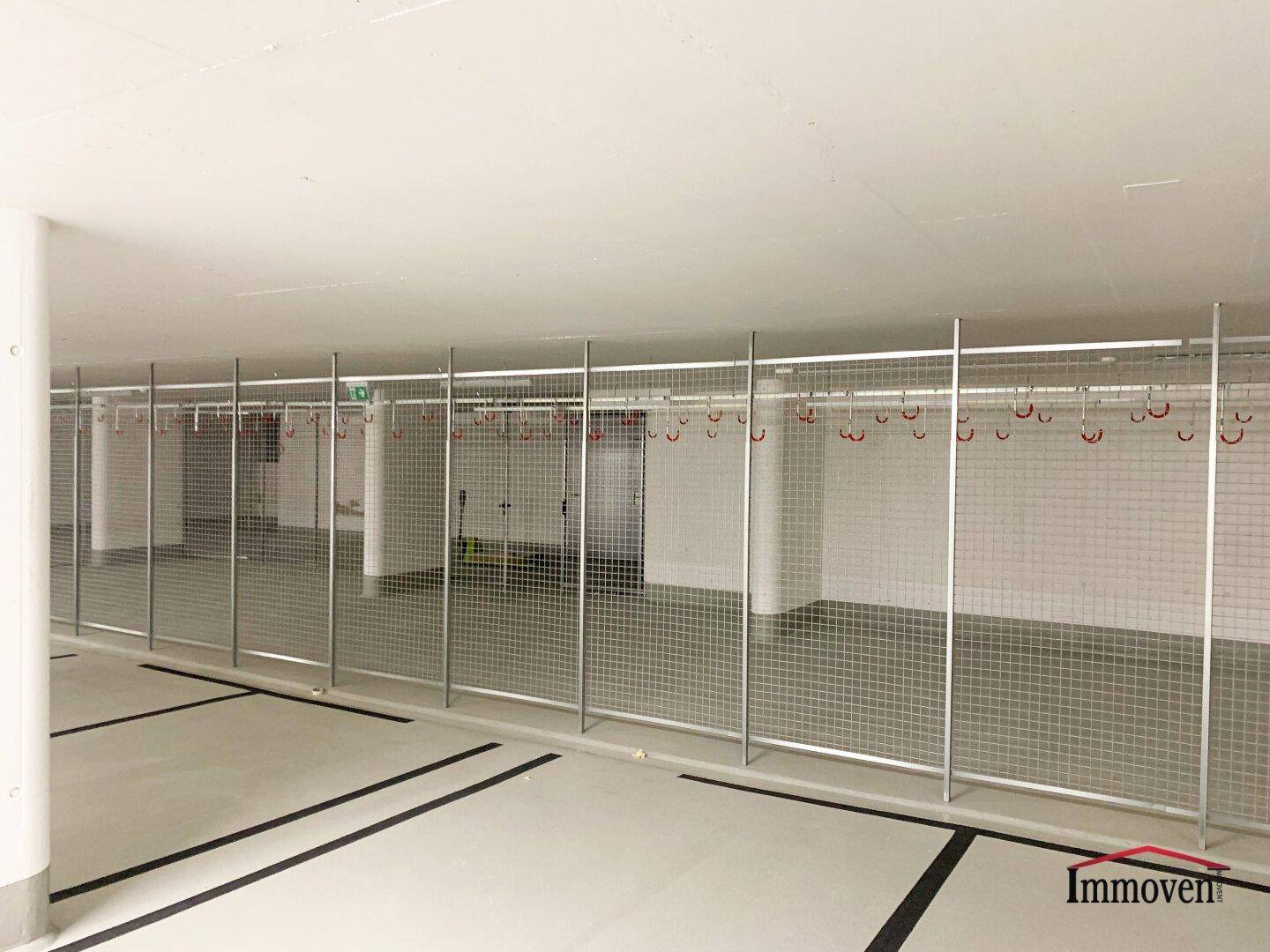 Fahrradraum oder Abstellbereich mit Metallgittern und Aufhängemöglichkeiten.