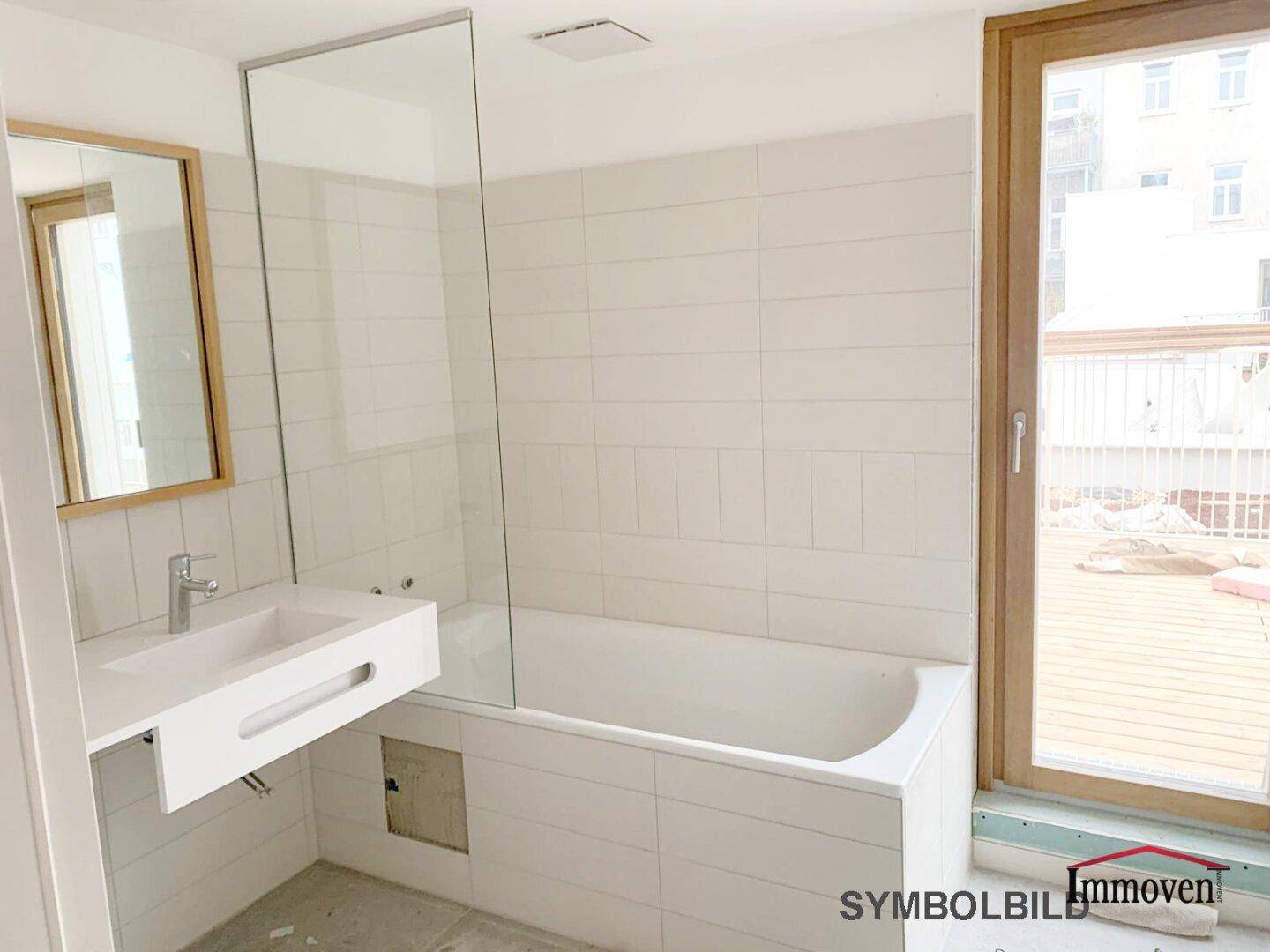 Modernes Badezimmer mit Badewanne, Glasabtrennung und großem Fenster für Tageslicht.