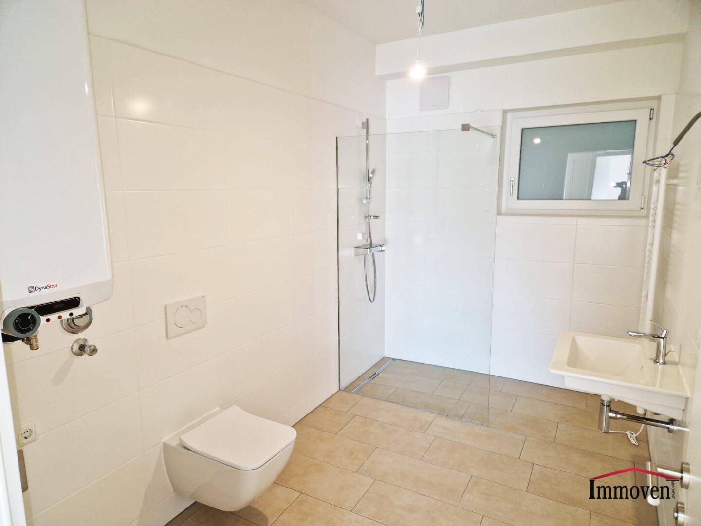 Modernes Badezimmer mit begehbarer Dusche, wandhängendem WC und Fenster für Tageslicht.