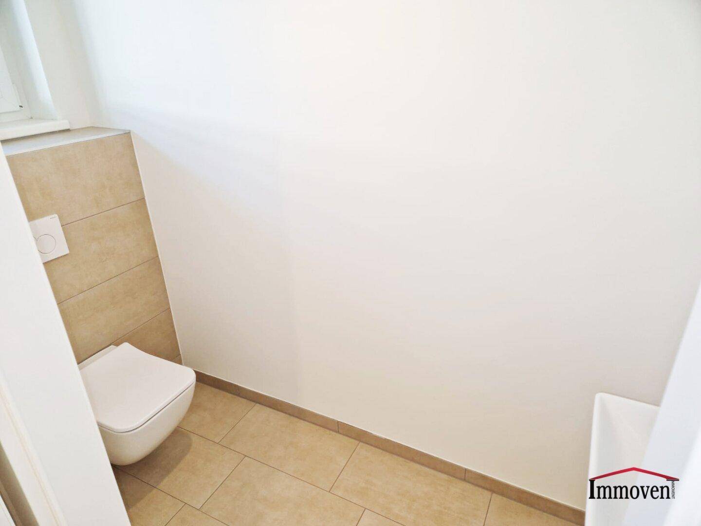 Kleines Gäste-WC mit wandhängendem WC und Fliesenboden, praktisch und funktional.