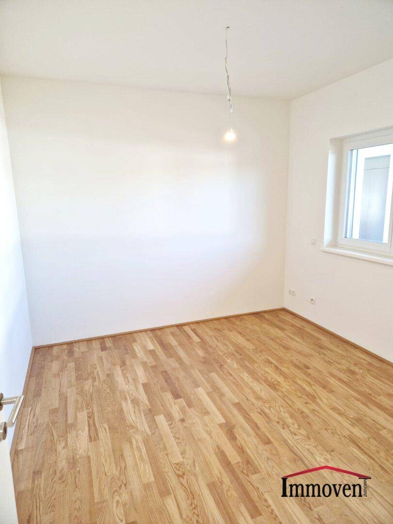 Kleinerer Raum mit Parkettboden und einem Fenster, ideal als Schlaf- oder Arbeitszimmer.