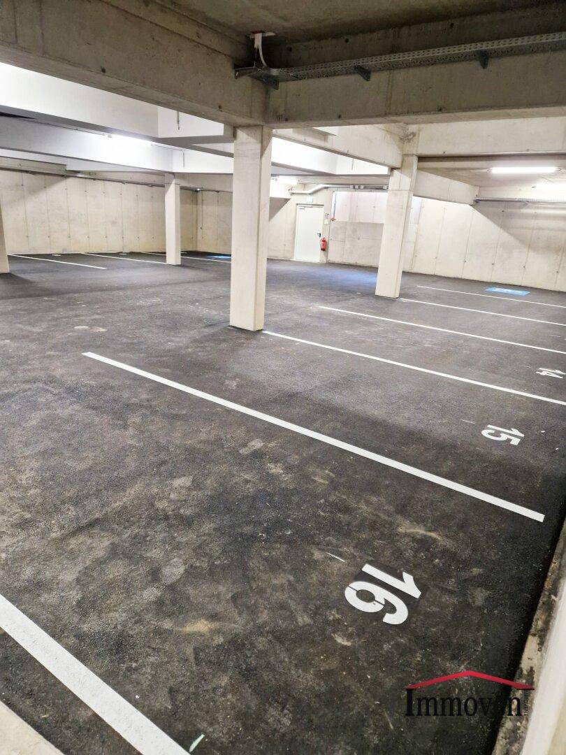 Geräumige Tiefgarage mit markierten Stellplätzen und Betonstützen.