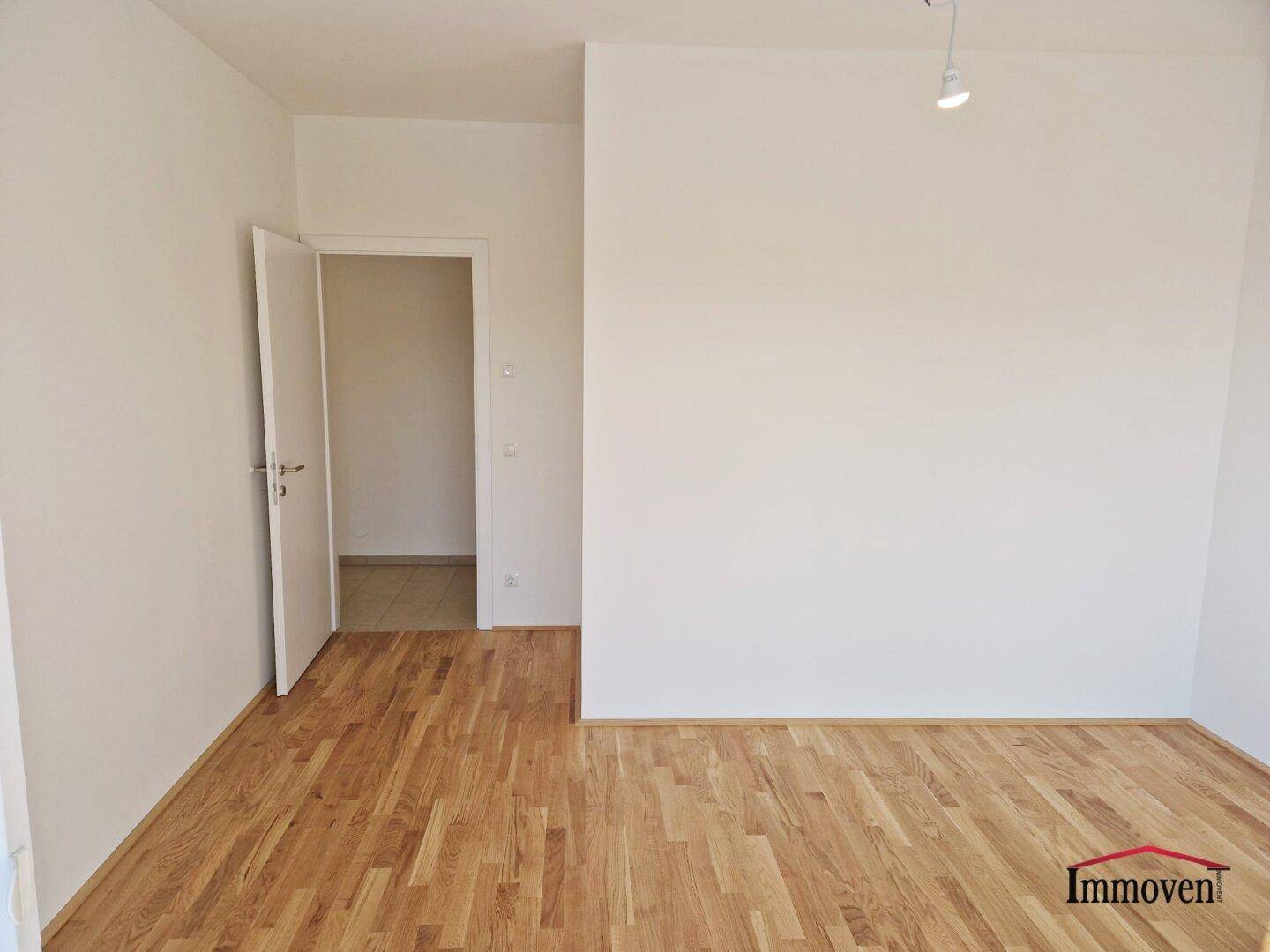 Leeres Zimmer mit Parkettboden und Zugang zu einem weiteren Raum, ideal für individuelle Gestaltung.