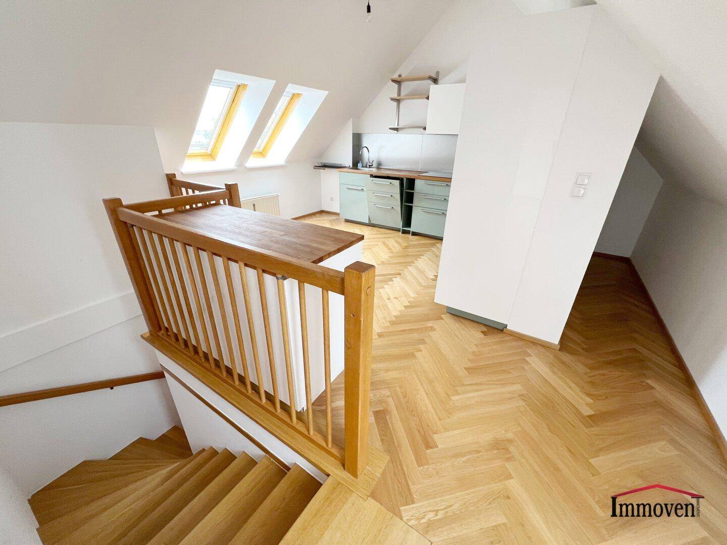 Offene Küche im Dachgeschoss mit Holzparkett, Dachfenstern und moderner Einbauküche.