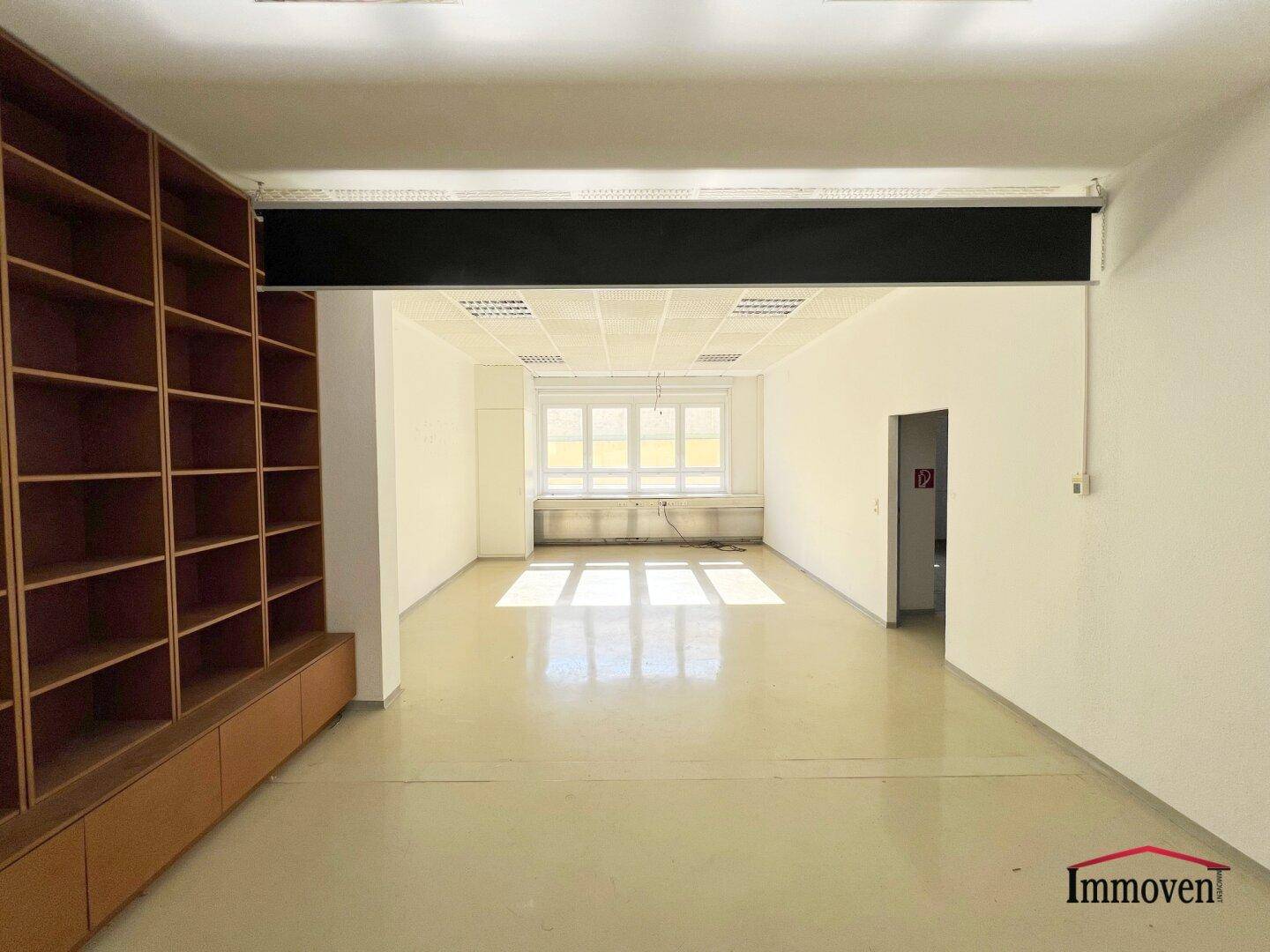 Großer, heller Büroraum mit Einbauregalen, abgehängter Decke und weitem Blick.