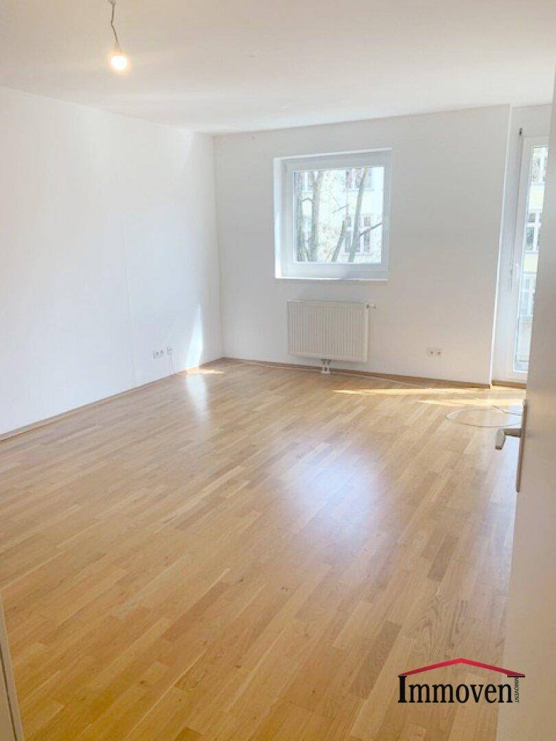 Geräumiges Schlafzimmer mit hellem Parkettboden und Fenster, das viel Tageslicht hereinlässt.