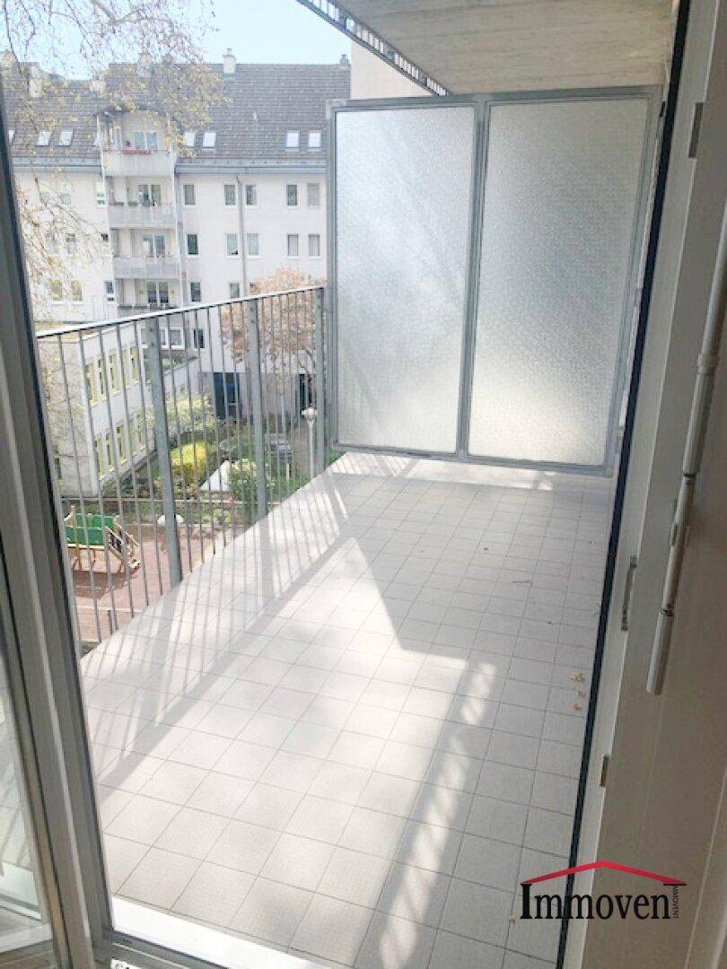Sonniger Balkon mit Fliesenboden und Metallgeländer, ideal zum Entspannen im Freien.