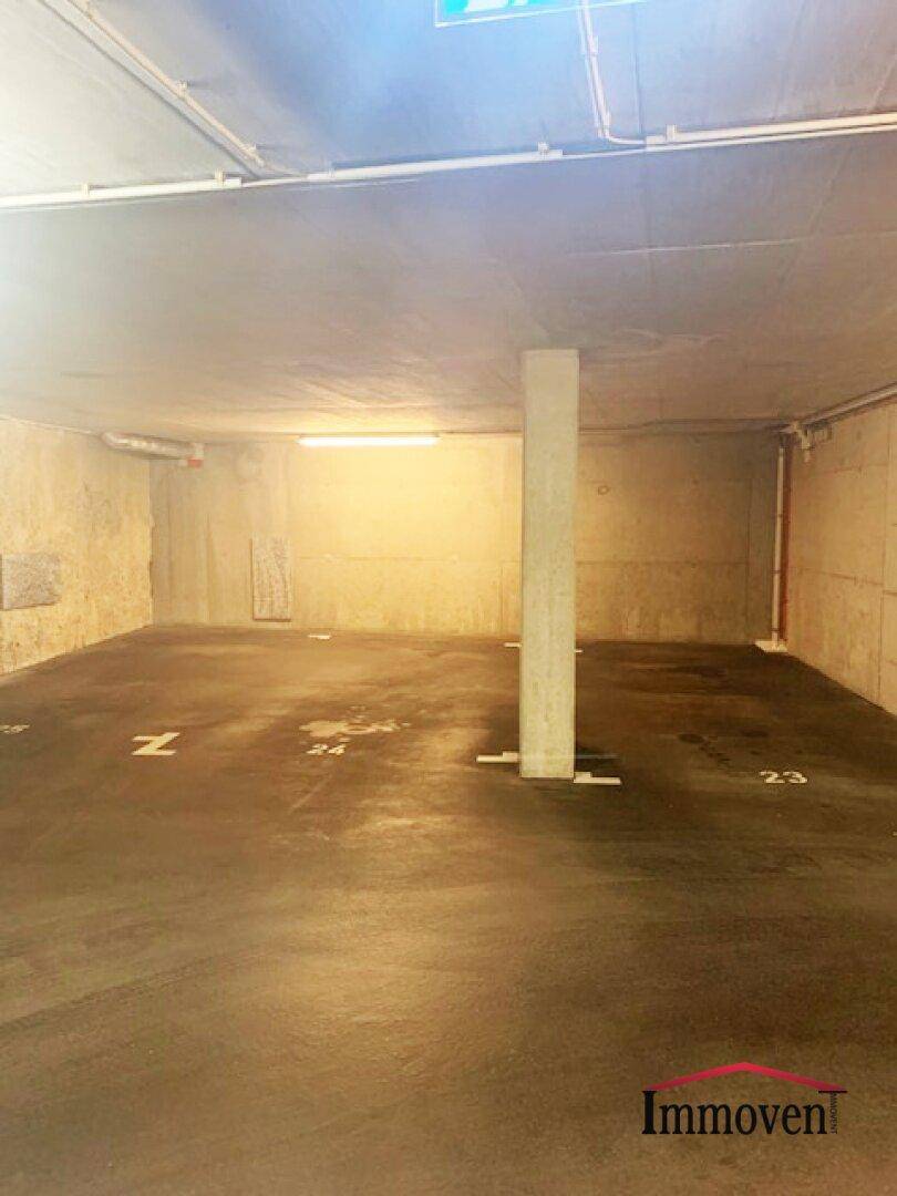 Weitere leere Parkplätze in einer Tiefgarage, gekennzeichnet mit den Nummern 23 bis 25.