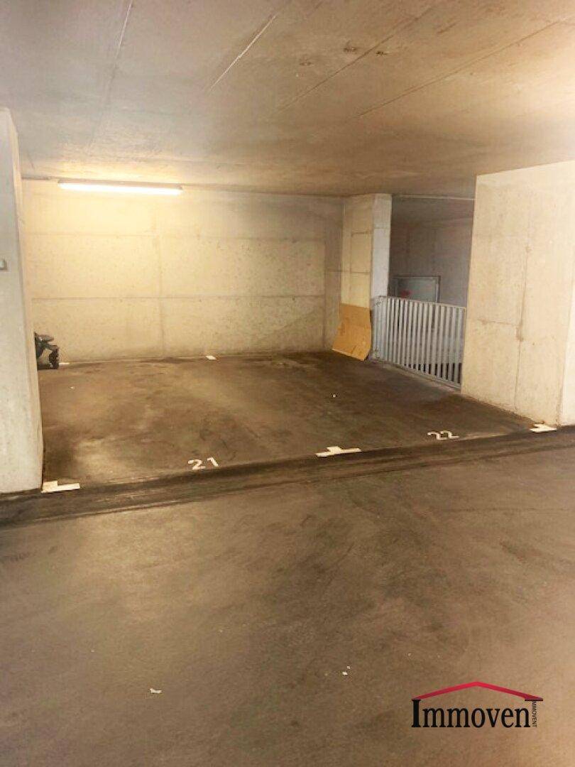 Markierte Parkplätze 21 und 22 in einer Tiefgarage mit Betonstützen und Treppenzugang.