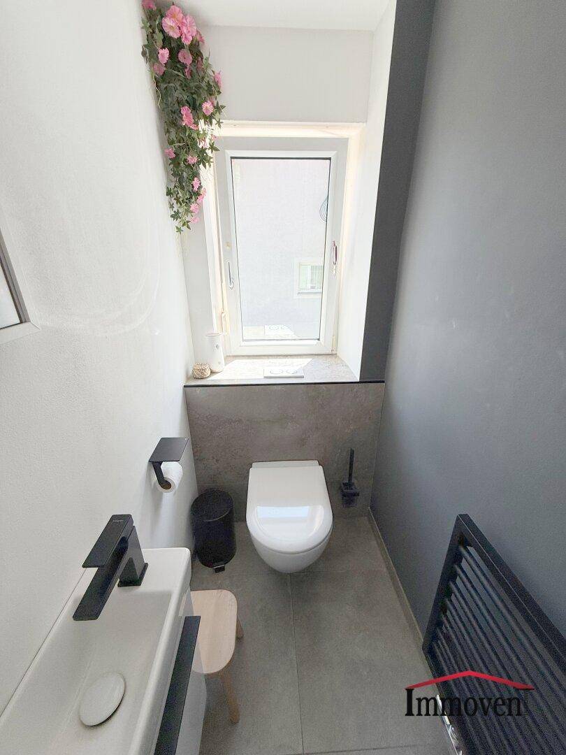 Kleines Gäste-WC mit modernem Design, Fenster und Wand-WC.