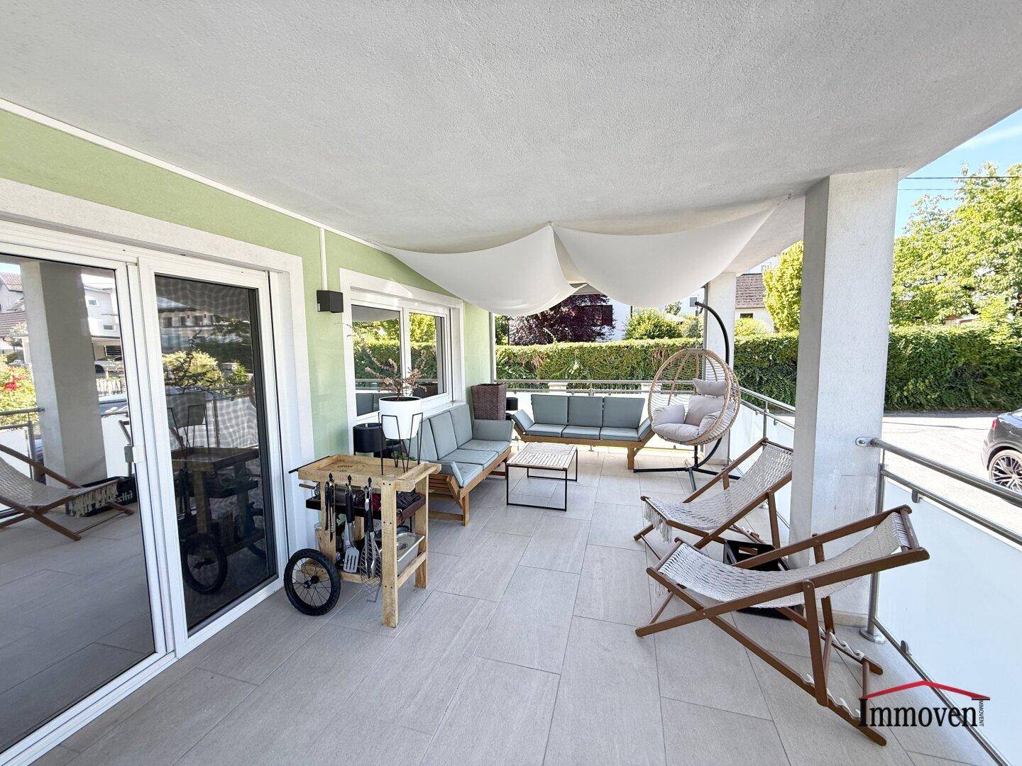 Geräumiger Balkon mit Lounge-Möbeln, Grill und Blick ins Grüne.