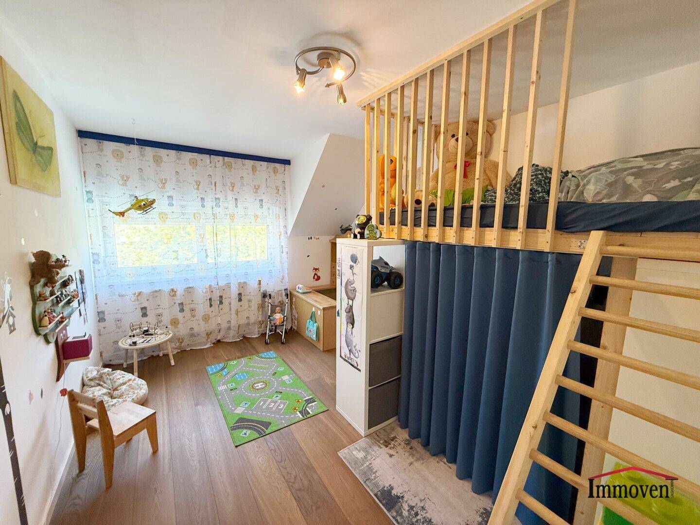 Gemütliches Kinderzimmer im Dachgeschoss mit Hochbett und Holzboden.