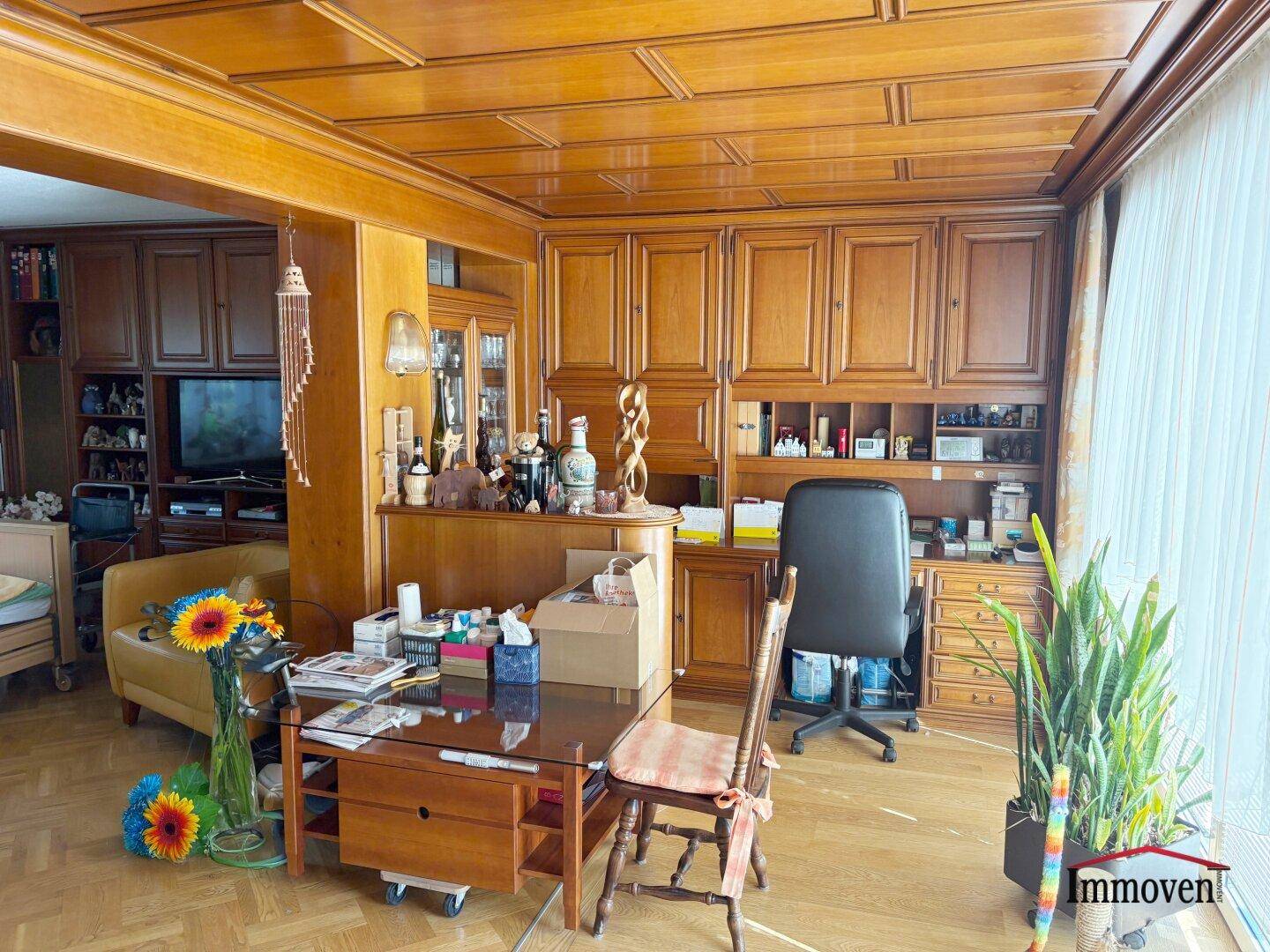 Gemütliches Wohnzimmer mit viel Holzvertäfelung, Einbauschränken und Parkettboden.
