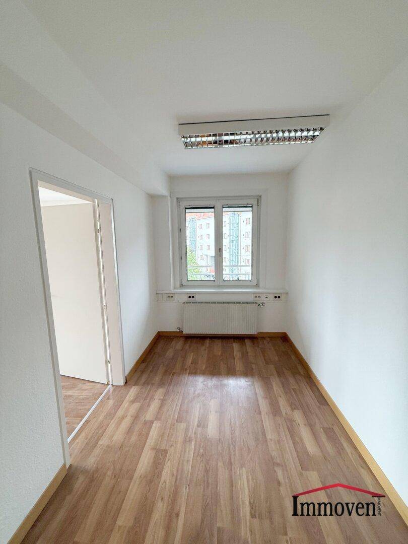 Leeres Zimmer mit Holzboden und Türzugang, bereit für neue Bewohner.