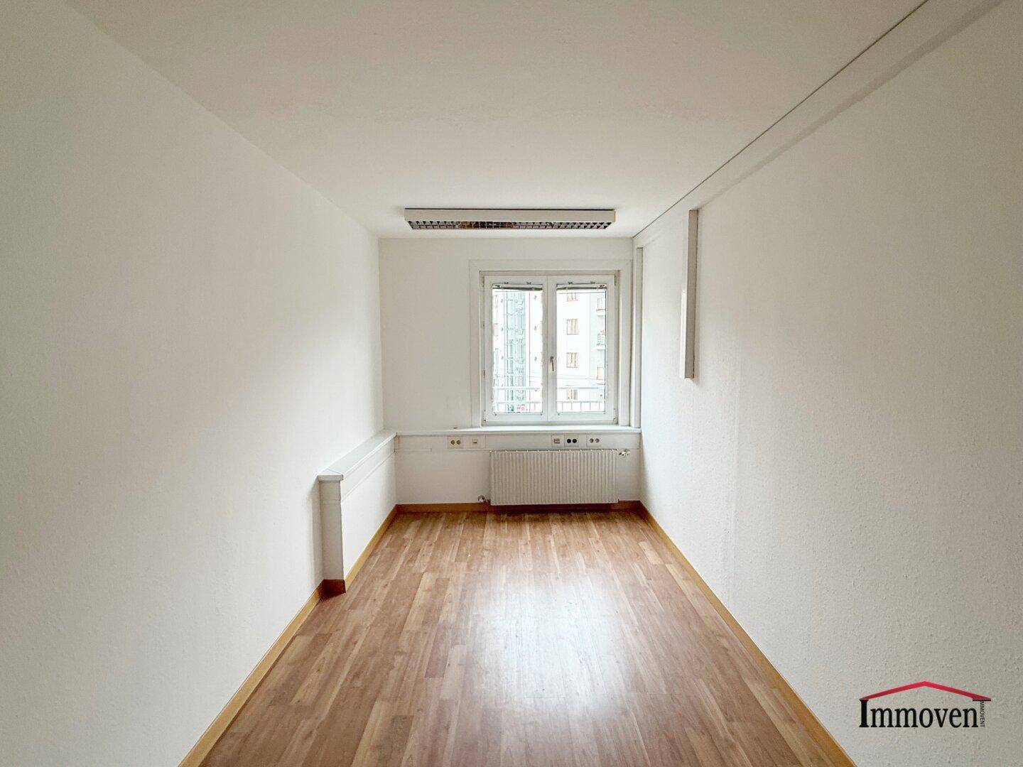 Schmaler Raum mit Holzboden und Fenster, geeignet als Schlafzimmer oder kleines Büro.
