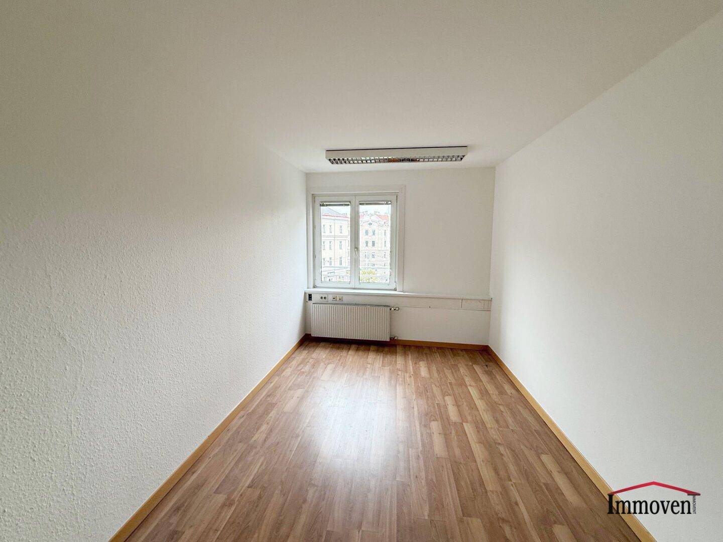 Leerer Raum mit Holzboden und Fenster, ideal für ein Schlafzimmer oder Arbeitszimmer.