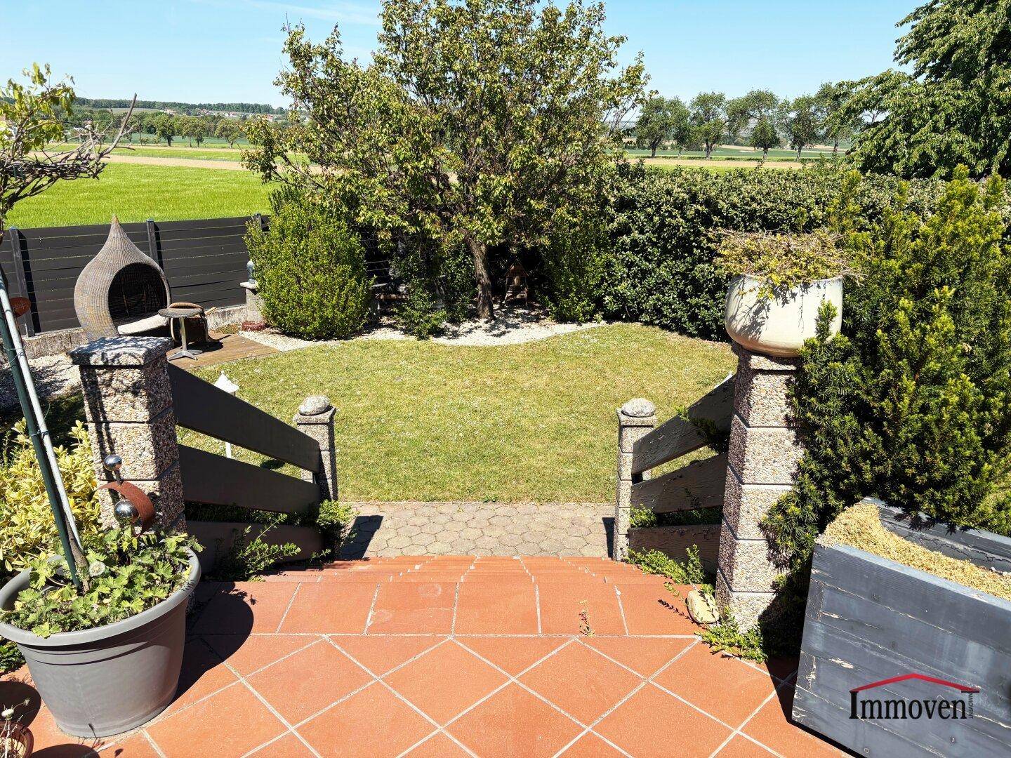 Gepflegter Garten mit Rasenfläche und weitem Blick über die umliegende Landschaft.