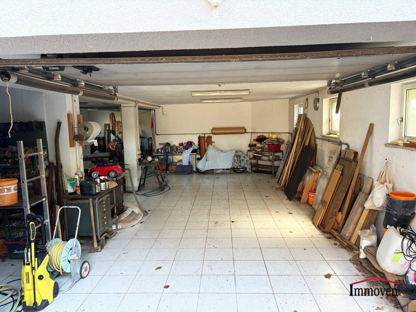 Geräumige Garage oder Werkstatt mit viel Platz, Werkzeugen und Fliesenboden.