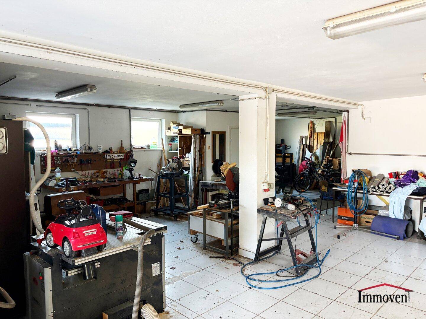 Weitere Ansicht der großen Garage, die als Werkstatt mit verschiedenen Geräten genutzt wird.