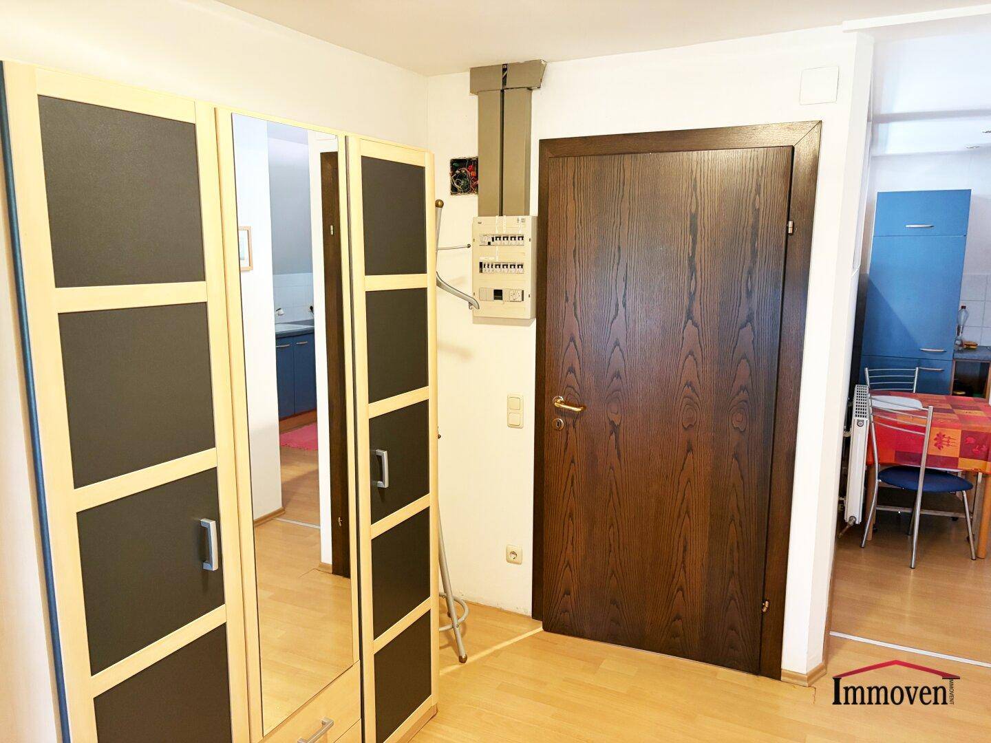 Flur mit Spiegelschrank und Blick in die angrenzende Küche.
