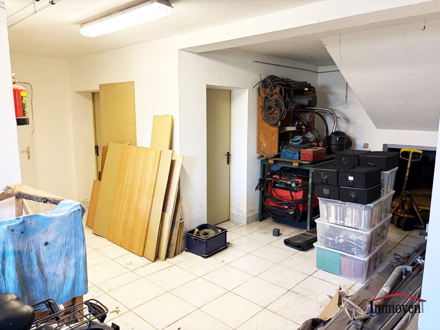 Lagerbereich in der Garage oder im Keller mit gestapelten Materialien und Kisten.