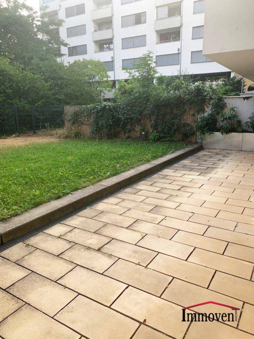 Terrasse und Garten mit Blick auf die umliegenden Gebäude, bietet eine private Grünfläche.