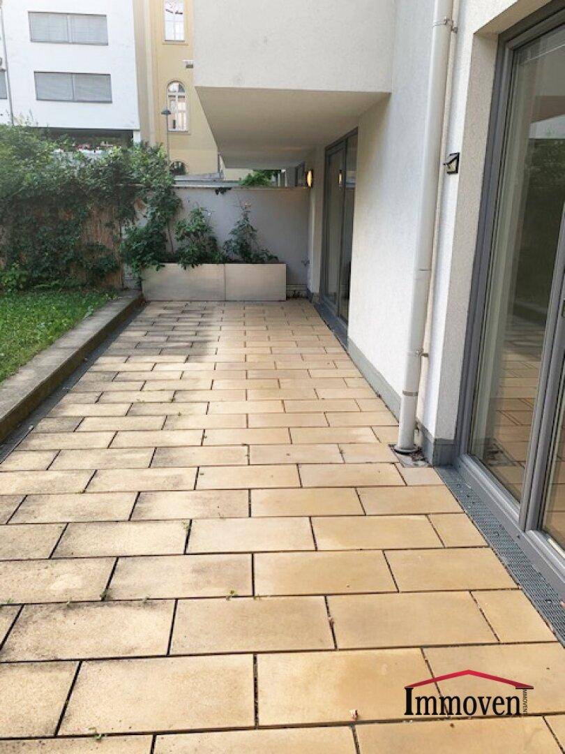 Großzügige gepflasterte Terrasse mit Zugang zum Garten, ideal für entspannte Stunden im Freien.