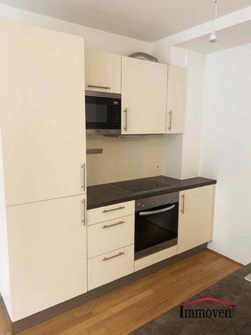Detailansicht der modernen Küchenzeile mit integriertem Backofen, Mikrowelle und Kochfeld.