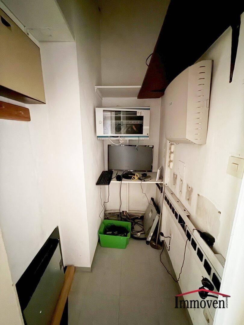 Kleiner Abstellraum mit Regalen, Technikgeräten und Kabeln, der als Serverraum genutzt werden könnte.