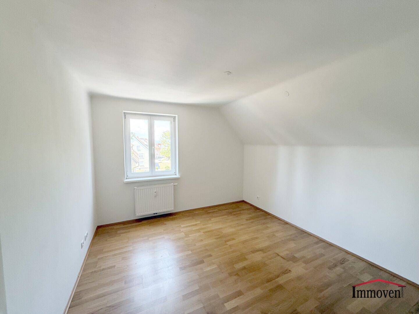 Lichtdurchflutetes Zimmer mit Parkettboden und Dachschräge, bereit zur individuellen Gestaltung.