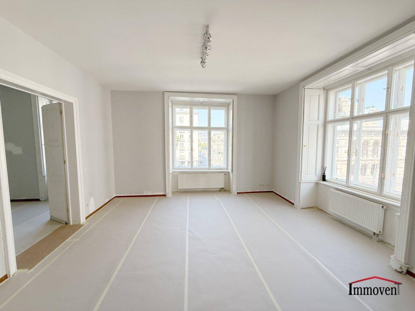 Helles, frisch renoviertes Wohnzimmer mit hohen Decken und großen Fenstern, bereit für neue Böden.