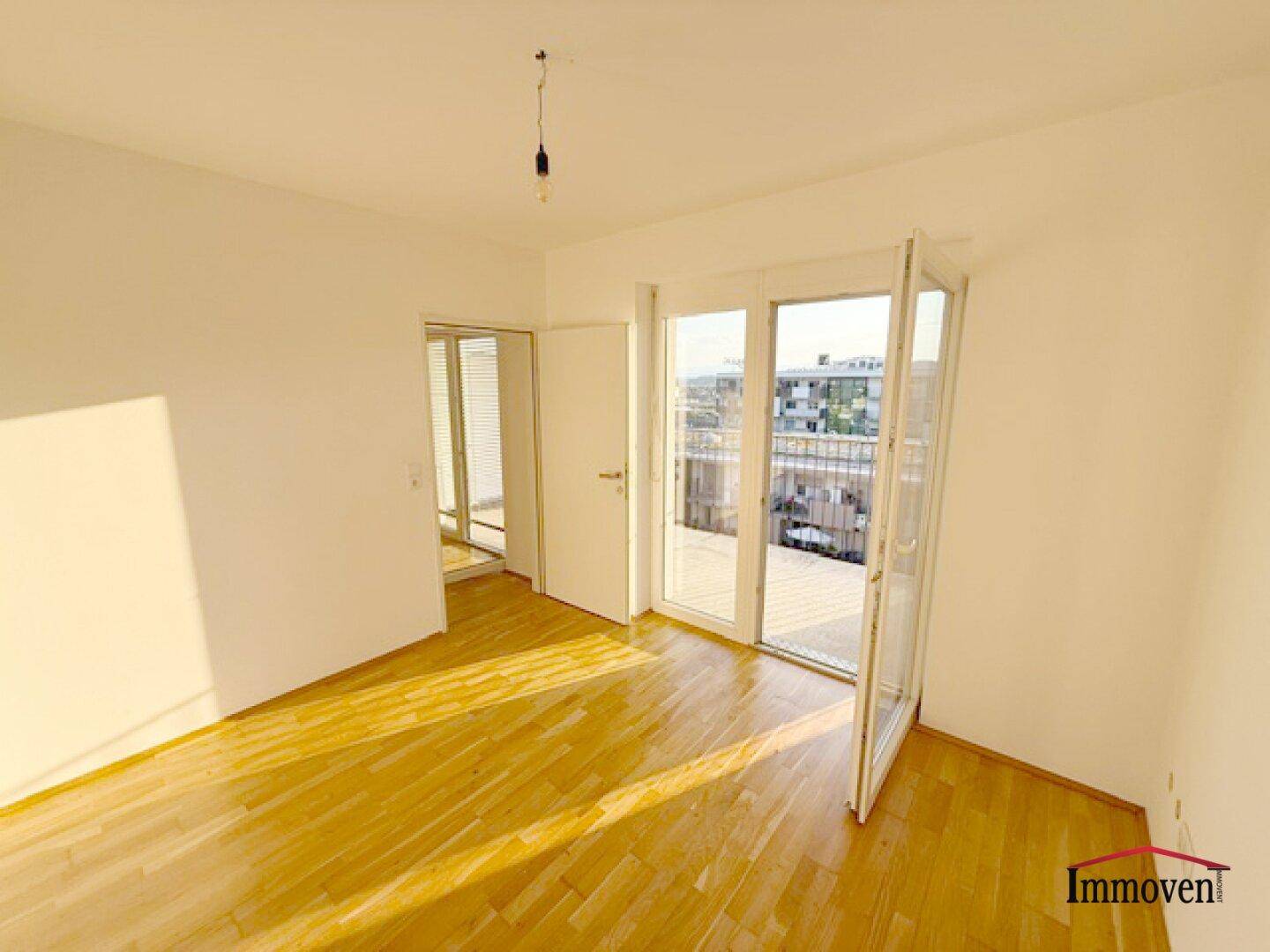 Helles Schlafzimmer mit Holzboden und direktem Zugang zu einem Außenbereich, gut beleuchtet.