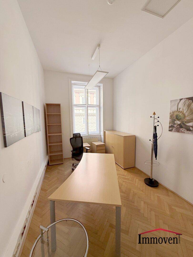Ruhiges Einzelbüro mit Holzparkett, einem Schreibtisch und einem Fenster für natürliche Belichtung.