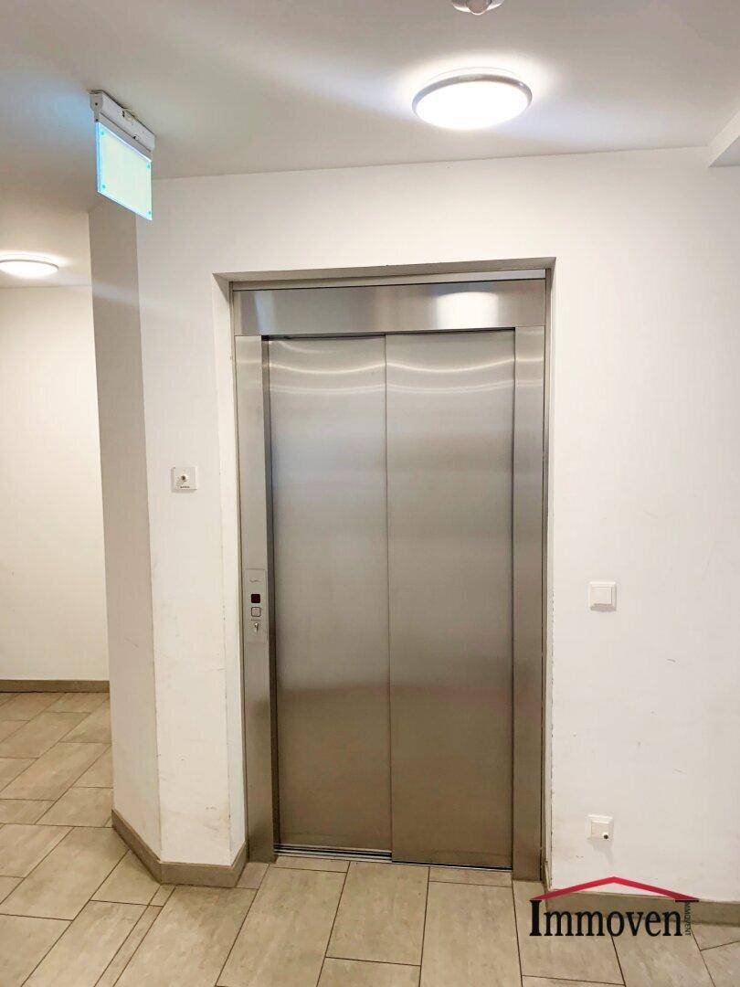 Gemeinschaftsbereich mit modernem Aufzug und Fliesenboden.