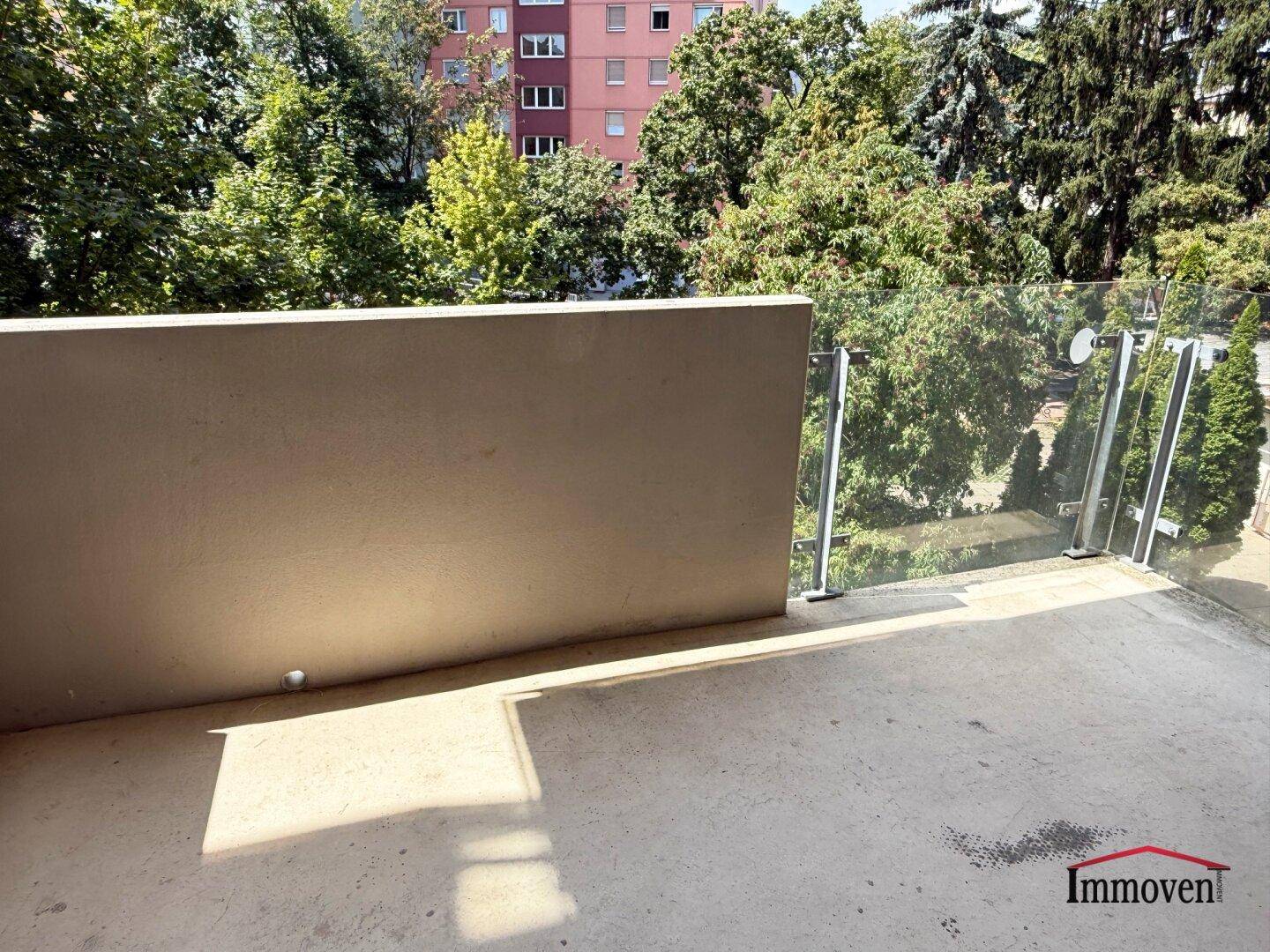 Sonniger Balkon mit viel Grün in der Umgebung, ideal zum Entspannen im Freien.