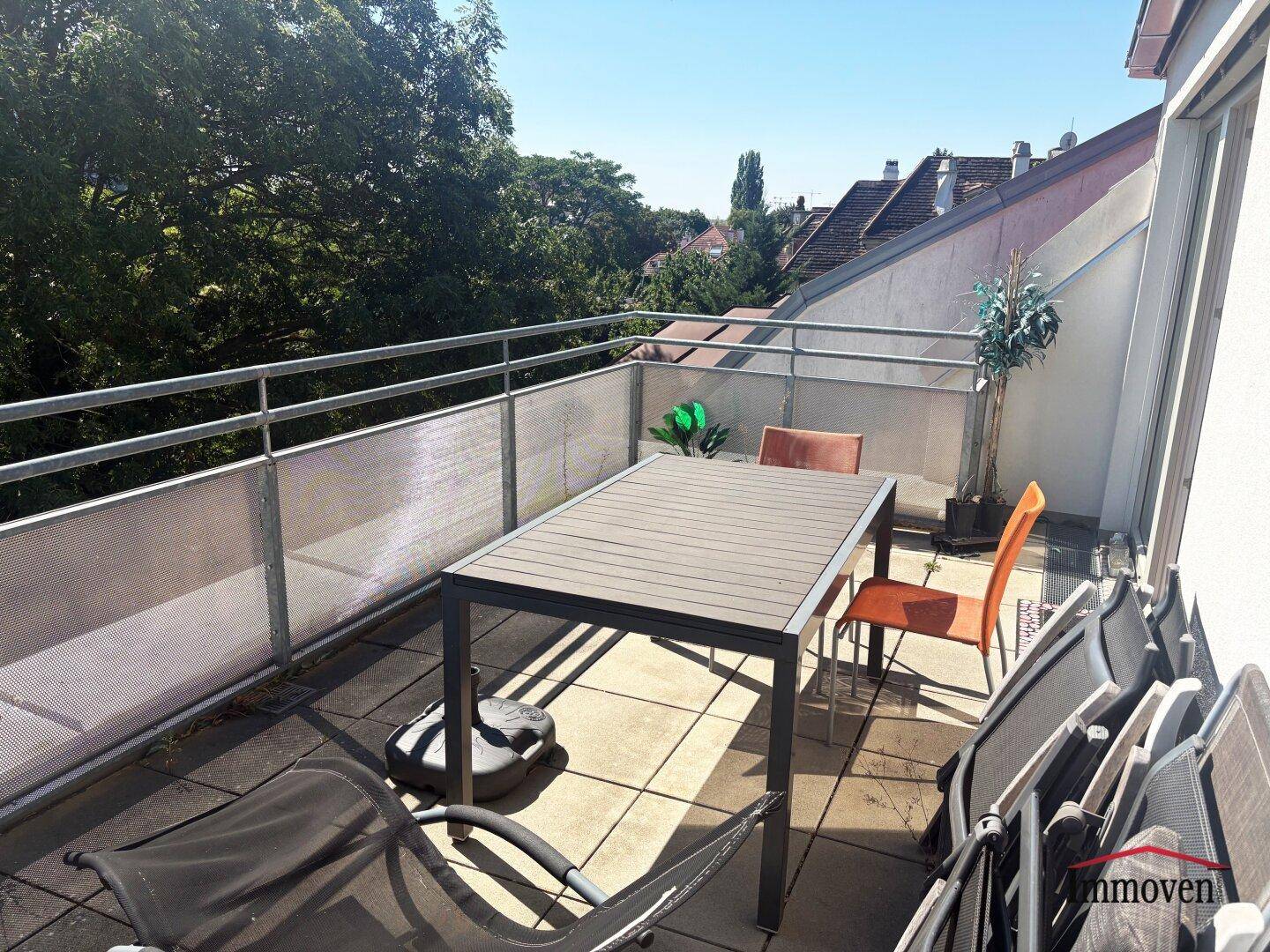Geräumiger Balkon mit Sitzgelegenheiten und Blick auf grüne Umgebung.