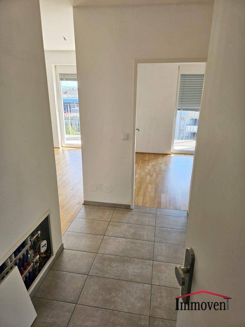 Heller Flurbereich mit Fliesenboden, der zu den verschiedenen Zimmern der Wohnung führt.