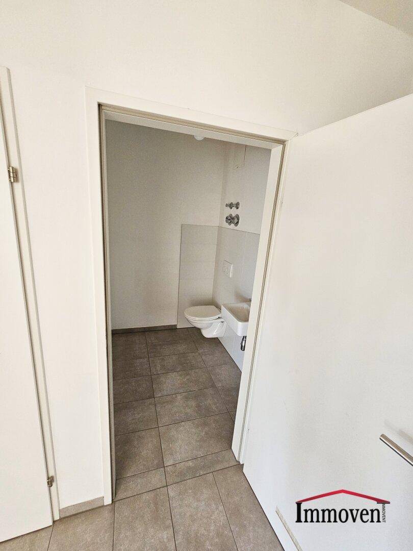 Separates Gäste-WC mit Toilette und kleinem Handwaschbecken, praktisch und funktional.