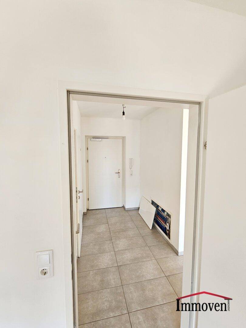 Eingangsbereich mit Fliesenboden und Zugang zur Wohnung, hell und einladend gestaltet.