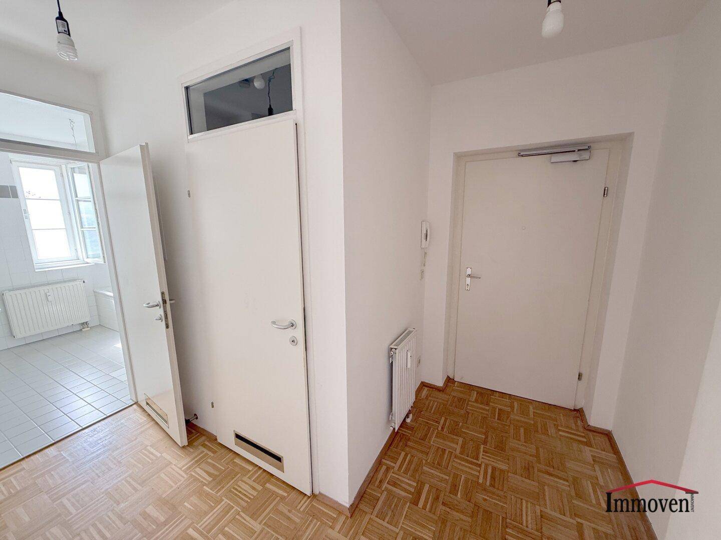 Eingangsbereich mit Parkettboden und Zugang zu weiteren Räumen der Wohnung.