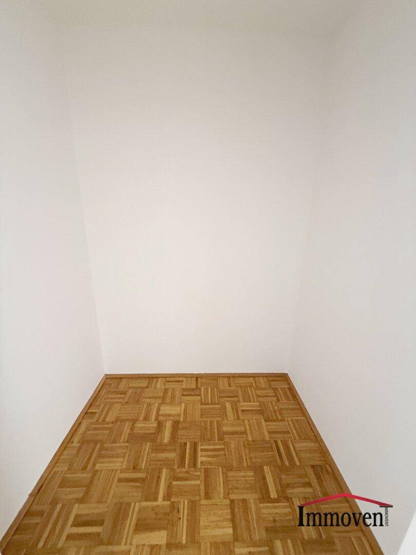 Kleiner Raum mit Parkettboden und weißen Wänden, nutzbar als Abstellkammer.