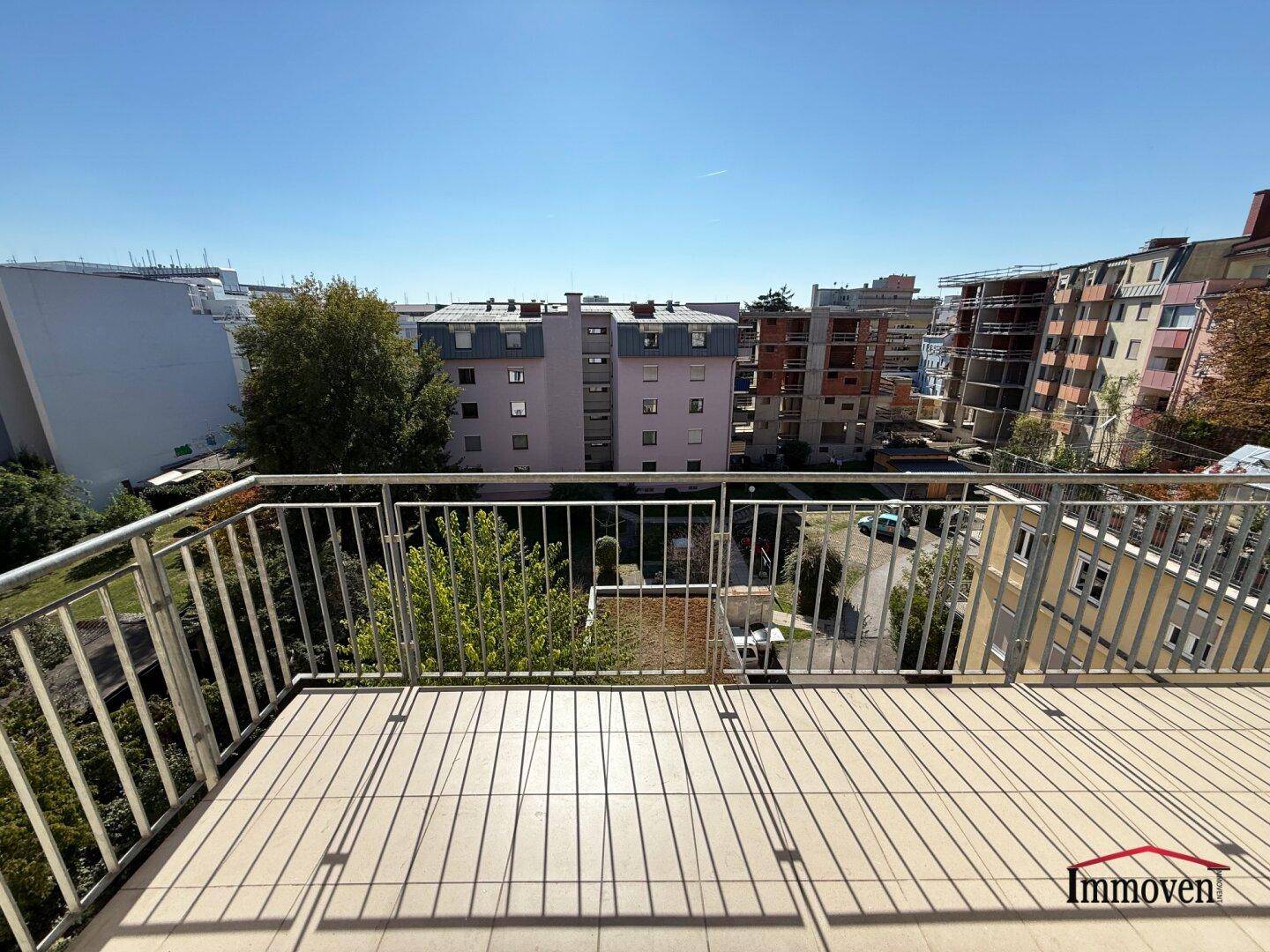 Geräumiger Balkon mit Fliesenboden und Metallgeländer, bietet einen weiten Blick.
