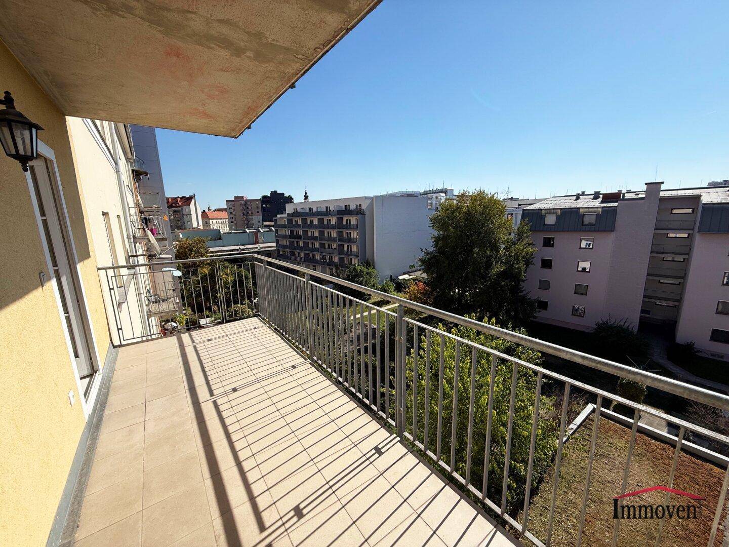 Sonniger Balkon mit Fliesen und Metallgeländer, bietet eine gute Aussicht.