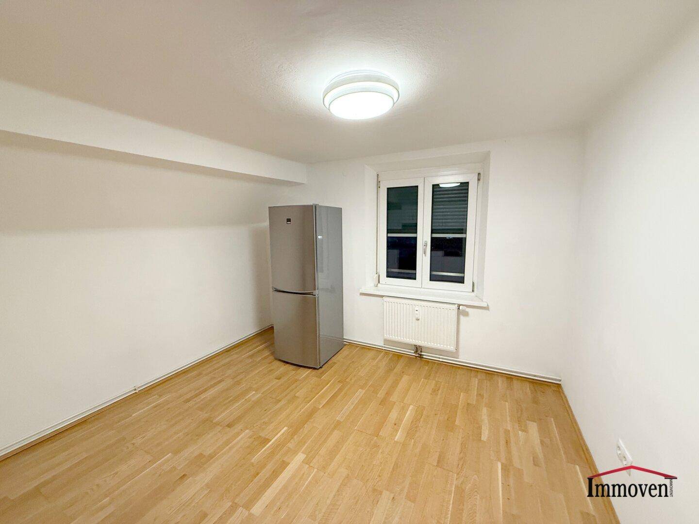 Heller Raum mit einem großen Kühlschrank und einem Fenster, das natürliches Licht spendet.