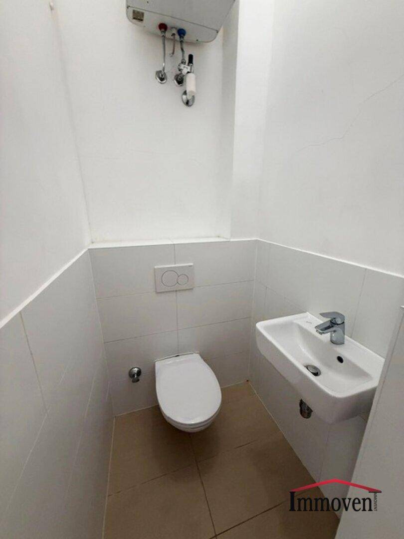 Kleines Gäste-WC mit wandhängender Toilette und Handwaschbecken, funktional und hell.