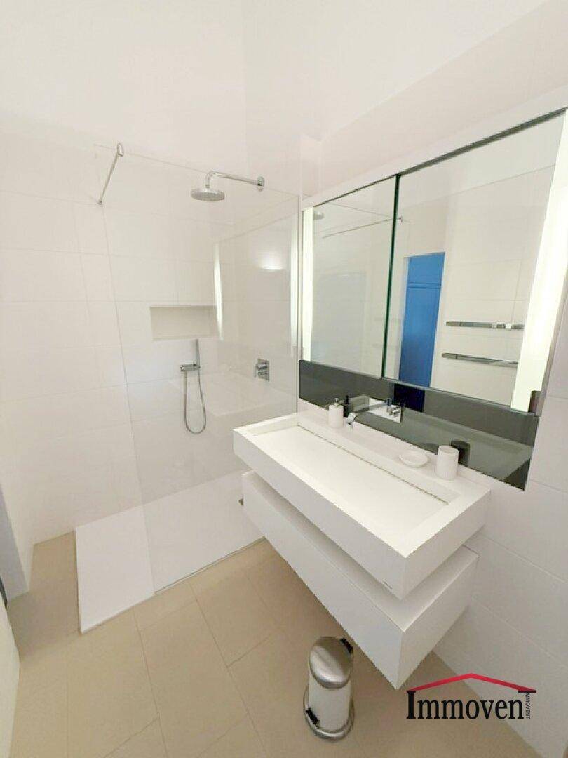 Modernes Badezimmer mit begehbarer Dusche und stilvollem Waschtisch.