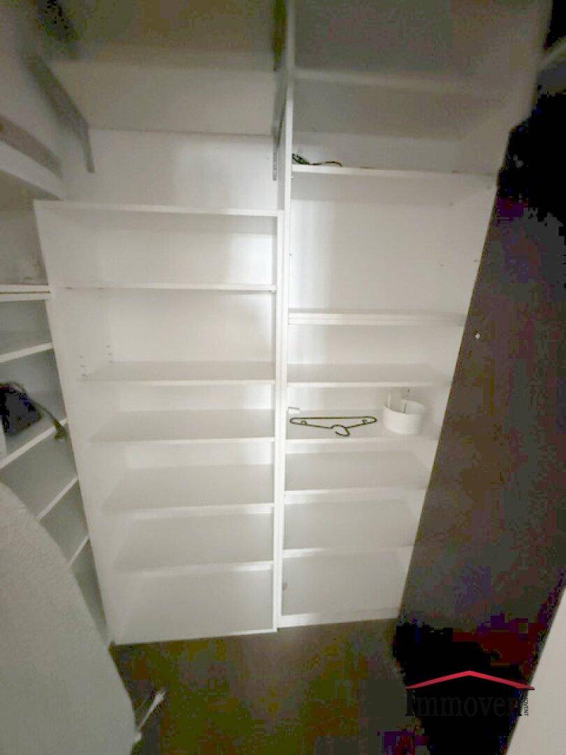 Geräumiger begehbarer Kleiderschrank mit vielen Regalen für Stauraum.