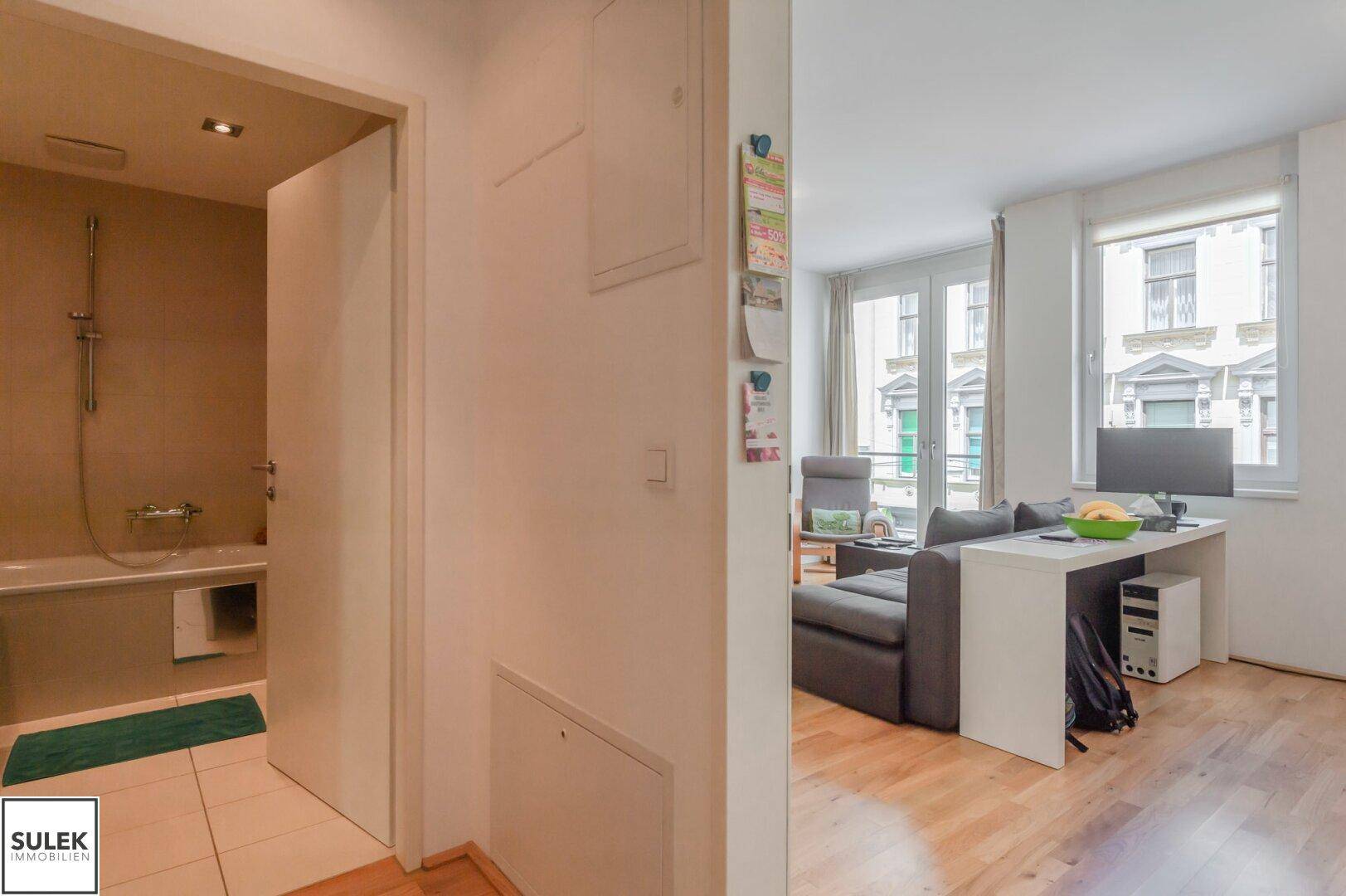 Übergangsbereich zwischen Badezimmer und Wohnbereich mit Holzboden.