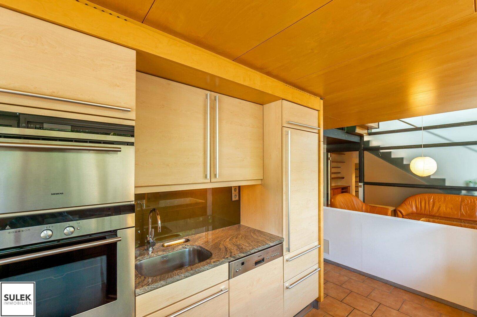 Einbauküche mit Holzfronten, Siemens-Ofen, Spülbecken und integriertem Kühlschrank.